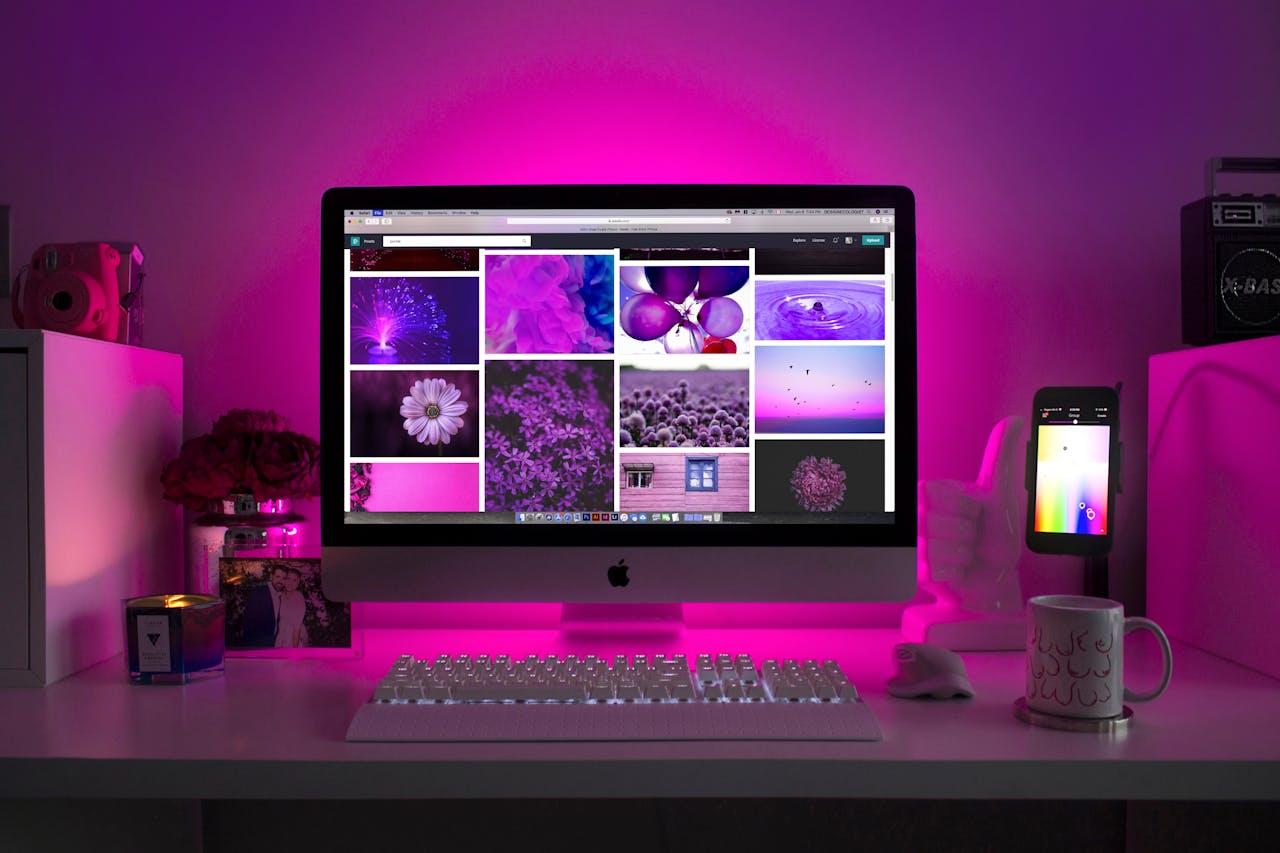 services-01 Modern desk setup with neon lighting and a desktop computer displaying colorful images.