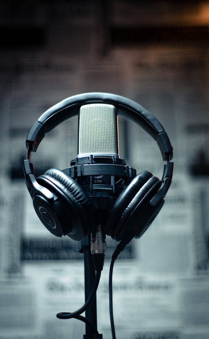 contact-img Microphone with headphones in a studio environment, perfect for sound recording and podcasting.